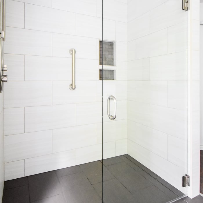 Walk in partially open shower with glass swinging door