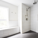Walk in curb-less shower with large format tile walls and floor with custom bench