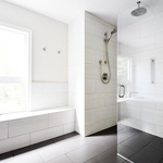 Walk in curb-less shower with large format tile walls and floor with custom bench