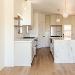 As anyone who works in residential home design, construction or real estate will tell you, the kitchen is both the heart and showpiece of most homes, whether it’s a simple farmhouse or a modern luxury home. For our Oregon Street custom home build, we wanted the kitchen to be especially stunning, so we pulled out all the stops with a custom backsplash, open shelving, high-end modern appliances and quartz countertops that extend to a gorgeous waterfall counter on the expansive kitchen island. F