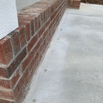 Patched drill holes to cement walkway.