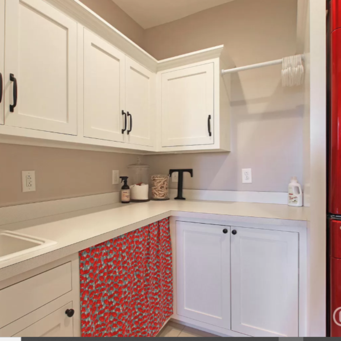 A smaller laundry room that is function centric. Stacked washer/dryer with a soaking sink and plenty of storage.