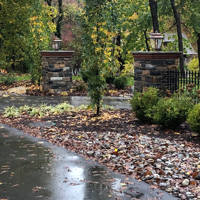 Finished stone columns with fencing and gas lights.