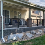Concrete tiles roof canopy over a stamped concrete patio slab with steel railings and custom made brick pillars.