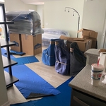 Sofa being wrapped from all sides some chairs padded and of course the floors are protected during the entire move process