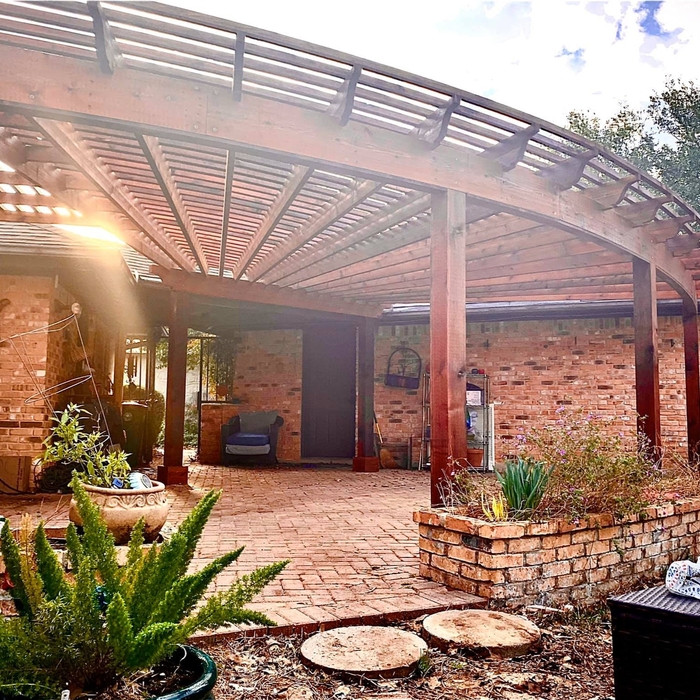 This cedar pergola follows the radius of the existing brick patio!