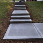 Perfectly formulated concrete walkway staircase with stair winders down to back porch.