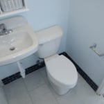 Updated the sink, tile, toilet, and tiled the floor and added an accent trim with the blue backsplash tile.