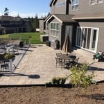Paver patio with adjacent composite deck and black aluminum railing