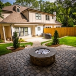 This shot showcases the gorgeous upper level paver patio created. This patio gives a great view of the house while being able to enjoy the wonderful gas fire pit.