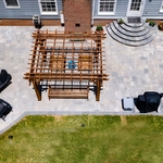 Enjoy this birds eye view photo of this jaw dropping paver patio project. This view truly shows all the aspects involved in this install - Gas fireplace, beautiful catalina pavers with a blu 60 border, half moon stairs, pergola, and a seating wall.