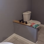 A picture of finished knee wall , toilet and base boards ,trim completion and painting done