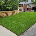 Front yard with horizontal fencing, sod, and lighting.
