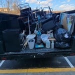 Dump trailer full of office supplies and desk and chairs.