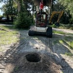 Skid Steer with Auger Attachment creating a hole.