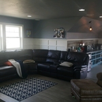 Picture of seating in front dormer with wet bar in back ground
