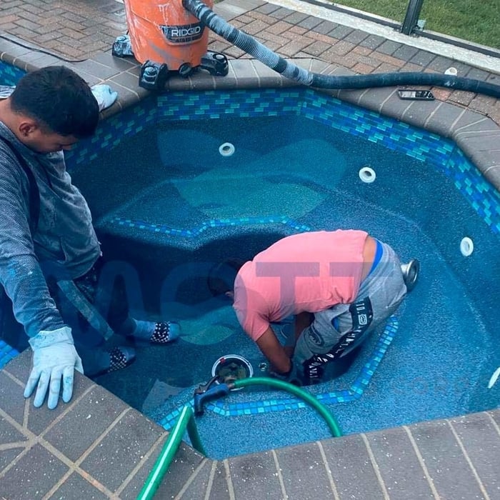 Cleaning drain and removing debris after plastering midnight blue plastering with pebbles