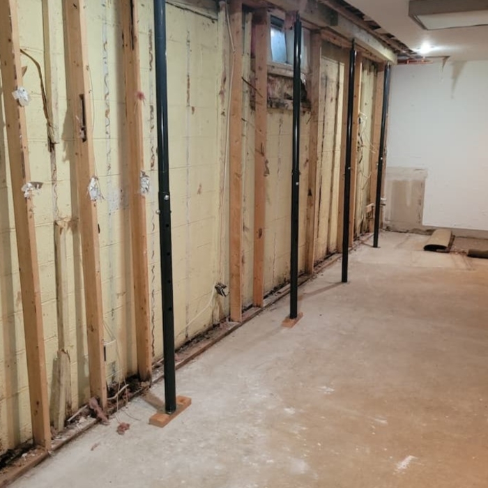Installation of metal jacks to transfer the weight load of the house away from the foundation during foundation repair