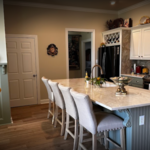 the redesigned island in the Larryson family's kitchen remodel by Alta Renovations. Adorned with luxurious marble countertops and customized to perfection, this island serves as the focal point of culinary creativity and social gatherings. With extended seating and integrated storage solutions, it effortlessly blends practicality with elegance, embodying the essence of traditional living at its finest.