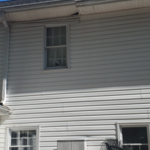 The damaged siding piece seen from a distance. It was all the way up there, unpleasant thing too look at
