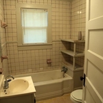 Before the makeover, this bathroom features outdated fixtures and monotone colors.
