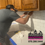 Handyman installing tile backsplash