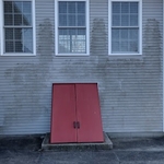 Before Power Pros pressure washed the siding and doors. There's discoloration, mold, algae and mildew covering the vinyl siding.