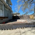 Hollandstone driveway extender is installed with a perimeter of Brussel Block to ensure a level patio along an uneven driveway.