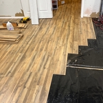 In process of installing laminate flooring over cement floors in larger room attached to small office. What you are looking at is a smooth transition between rooms and the water barrier that we installed between the flooring.