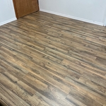 After… completion of installation of laminate flooring in larger connecting room attached to small office.