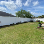 Backyard view of brand new white vinyl fence.