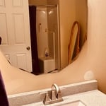 After photo of newly installed countertop , faucet and mirror.