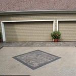 New patio with design in center using granite and charcoal colors to highlight