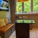 Kitchen with new built-in banquet seating with rust leather cushio and added throw pillows.