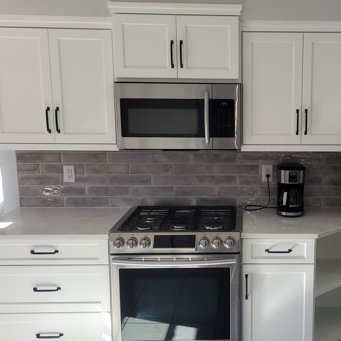 Refaced with a shaker white door with new moldings and hardware.