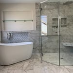 Master Bathroom with barrier free shower with custom glass shower enclosure. Free standing tub & tub filler. Niches, body sprays, rain shower, corner bench inside shower. Porcelain tile that mimics marble throughout bathroom.
