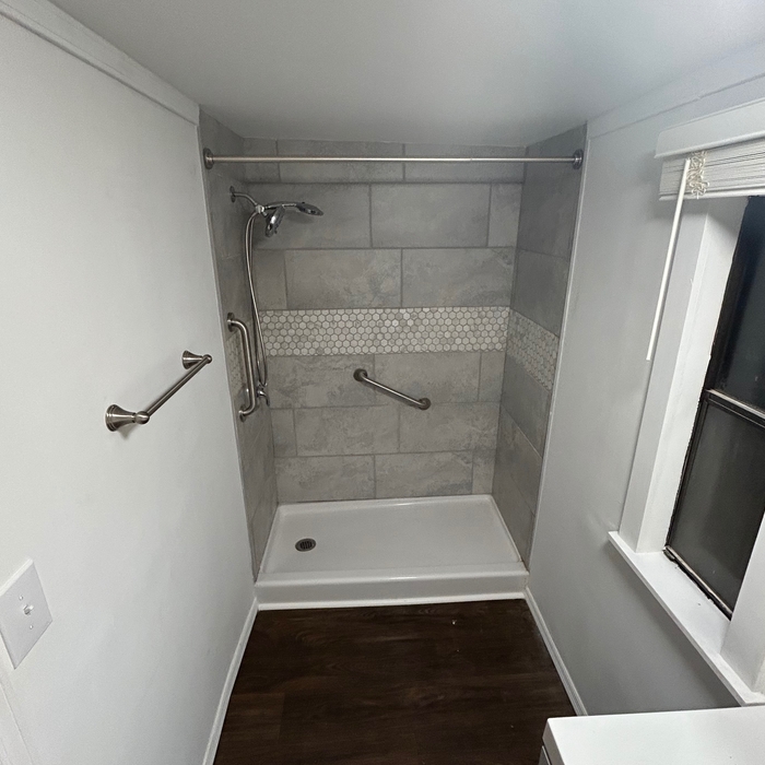 Zoomed out image of shower. Brab bar installion for age resolutions