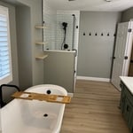 Overall view with standalone tub, new quartz vanity top with under mounted sinks, and lighted mirrors