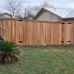 Six foot tall, cedar privacy fence, with metal posts, cap and trim double drive gate and single walk gate.