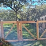 Wire fence with cedar wood trim and double swinging gate.