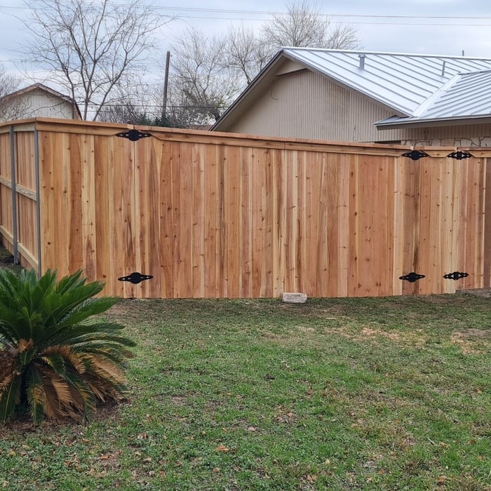 Cedar wood fence with a double and single drive gate, metal postmaster posts cap and trim.