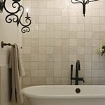 Stand-alone tub with a very warm and rustic full wall tile layout