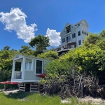 View from water of newly renovated house and boat house