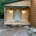 Front view of the log cabin entry room addition highlights the stunning front door with dual sidelights.