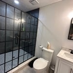 60x48 shower, toilet moved over 18inches, recessed, mirror, can lighting, tile flooring, vanity and sink.