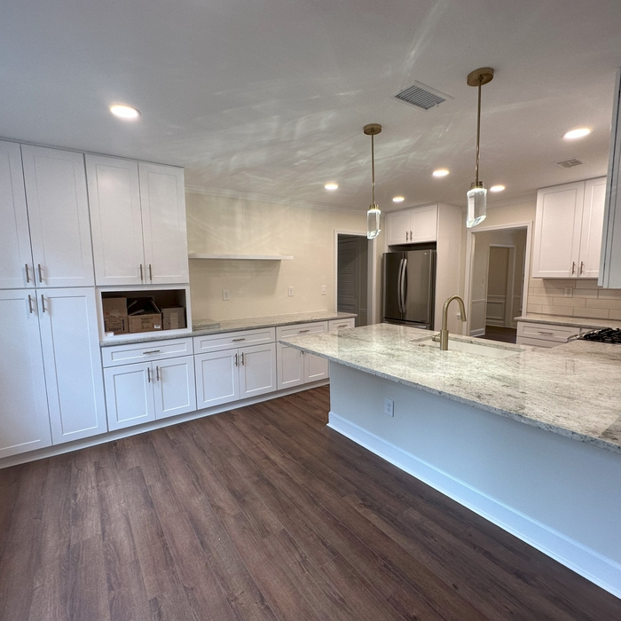 Step into an exquisitely remodeled kitchen, masterfully transformed by Yanover Construction. The kitchen's ambiance is one of refined beauty and contemporary sophistication, achieved through meticulous attention to detail and expert craftsmanship. The focal point of the space is the extended island/peninsula, thoughtfully designed to be both a culinary workstation and a social hub. Its expansive quartz countertop gleams under the gentle illumination of modern pendant lights, adding a warm and i