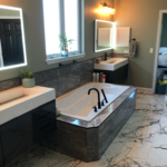 Bath remodel using the existing tub with new tile surround, floating vanities and lighted mirrors