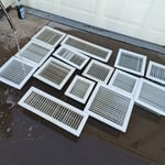 Cleaning and rinsing the registers. Some of the registers appear to be stained from smoke.