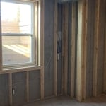 Final result; cleaned studs and block wall, ready for new insulation and drywall to be installed.