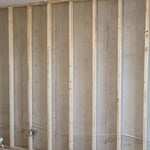 Final result; cleaned studs and block wall, ready for new insulation and drywall to be installed.